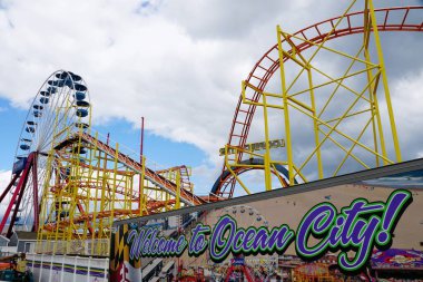 Okyanus Şehri, Maryland, ABD - 23 Mayıs 2025 Heyecan verici lunapark treni, dönme dolap ve canlı bir hoş geldin işareti