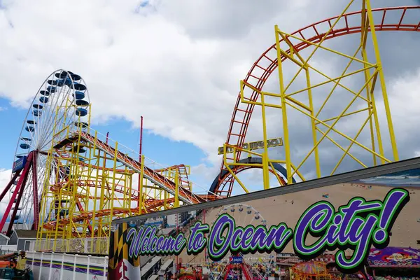 Okyanus Şehri, Maryland, ABD - 23 Mayıs 2025 Heyecan verici lunapark treni, dönme dolap ve canlı bir hoş geldin işareti