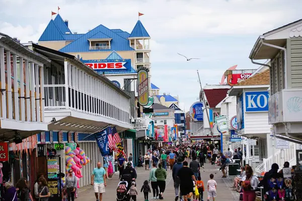Okyanus Şehri, Maryland, ABD - 23 Mayıs 2025 - Güneşli bir günde ziyaretçi ve satıcılarla dolu hareketli tahta kaldırım sahnesi
