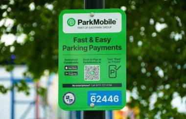 Ocean City, Maryland, ABD - 23 Mayıs 2025 - Park Mobil uygulaması için yeşil işaret ve kusursuz park işlemleri için QR kodu.