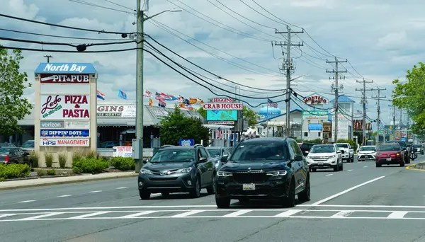Ocean City, Maryland, ABD - 23 Mayıs 2025 - Trafik yoğun sahil otobanında yol boyunca yerel işletmelerin geçmişine sahip