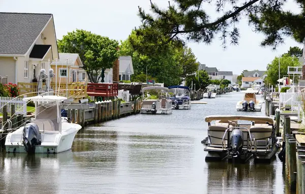 Okyanus Şehri, Maryland, ABD - 23 Mayıs 2025 - Kanal boyunca Assawoman Körfezi 'ne yanaşmış çeşitli tekneleri olan güzel bir kanal
