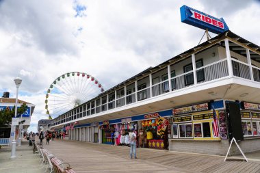 Okyanus Şehri, Maryland, ABD - 23 Mayıs 2025 - Dönme dolaba bakan tahta kaldırımda iş ve eğlence yerleri