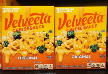 Wilmington, Delaware, ABD - 26 Haziran 2025 - Makarna ve brokoli üzerine zengin, altın portakallı peynir sosu içeren Velveeta peyniri sosu.