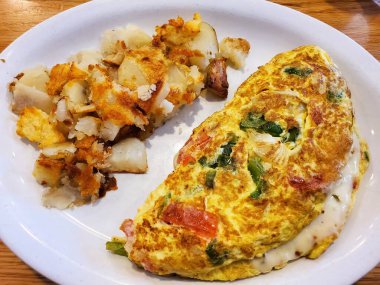 Kızarmış patates ve sebzeli omlet, yanında da patates..