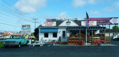 Lewes, Delaware, ABD - 12 Temmuz 2025 - Açık hava oturma ve canlı bir tente Matt 'in Balık Kampı' nda hoş bir atmosfer oluşturur..