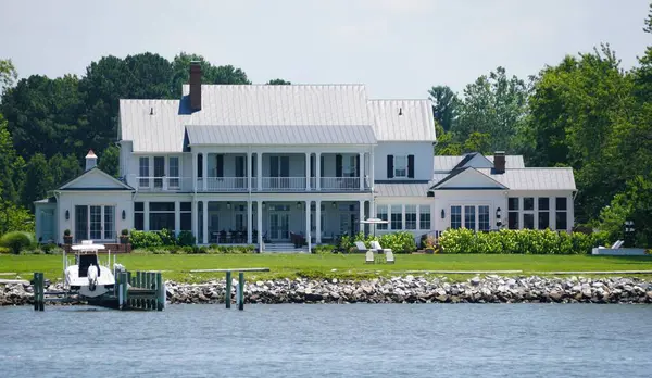 St Michaels, Maryland, ABD - 29 Haziran 2025 - Resimli rıhtım arazisi, geniş verandalı ve huzurlu rıhtımlı büyük bir ev.
