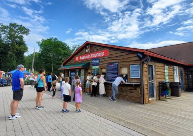 Tannersville, Pennsylvania, ABD - 19 Temmuz 2025 - Macera Merkezi 'nde sabırla bekleyen bir grup insan açık hava deneyimleri için hazır bekliyor.