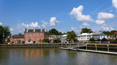 Delaware City, Delaware, ABD - 2 Ağustos 2025 - Central Hotel 'in panoramik manzarası, konutlar, yerel mağazalar ve bir yaz günü körfezdeki rıhtım manzarası