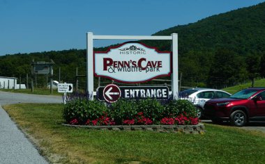 Merkez Salonu, Pennsylvania, ABD - 9 Ağustos 2025 Penn Mağarası ve Vahşi Yaşam Parkı 'nın girişini gösteren bir karşılama tabelası manzaranın ortasında bir macera vaat ediyor..