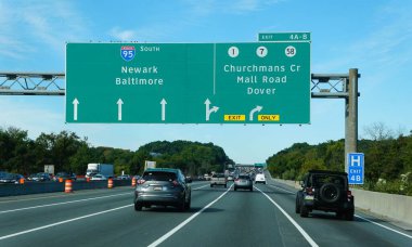 Delaware, U.S.A - Sept 21, 2025 - Traffic on I-95 South with sign into Newark, Baltimore and Route 1, 7 and 58 into Churchman Crossing, Mall Road and Dover