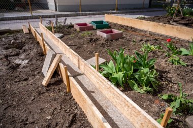 Ahşap kalaslarla sebze bahçesinden beton bir yol inşa etmek. Bahçıvanlığı geliştirmek için DIY projesi.