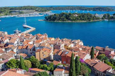 Hırvatistan 'ın Rovinj kentinin yukarısında mavi deniz ve adalı eski evler ve çatılar
