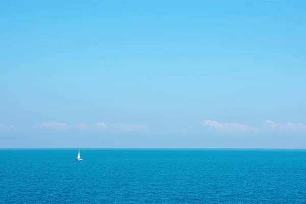 Bomboş Denizde Küçük Bir Yelkenli Boş Gökyüzü Küçük Bulutlarla — Stok fotoğraf