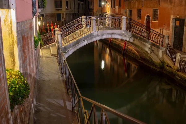 Quiet and calm still life small stone bridge spanning canal by night, Venice, Italy