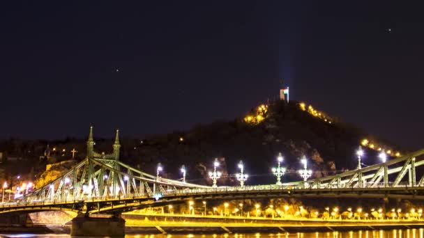 背景にシタデッラ像と自由の橋とゲレルトの丘の夜のタイムラプス録音で移動星や雲 ブダペスト ハンガリー — ストック動画