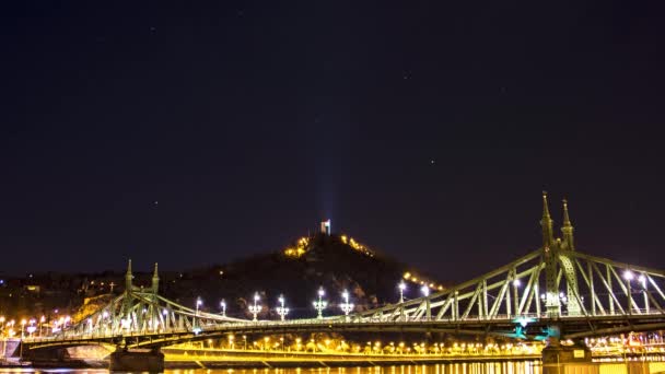 匈牙利布达佩斯 自由桥和盖尔特山夜间移动的星星和云彩 背景是城堡雕像 — 图库视频影像