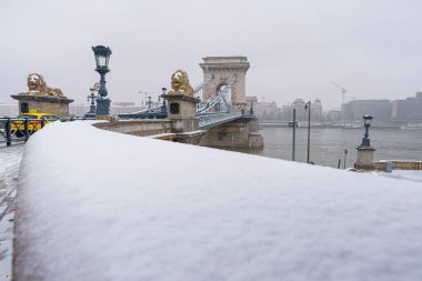 Budapeşte 'nin ikonik köprüsü, Tuna Nehri üzerindeki Zincir Köprüsü, kışın yayılmış ışık, normal açılı lens.