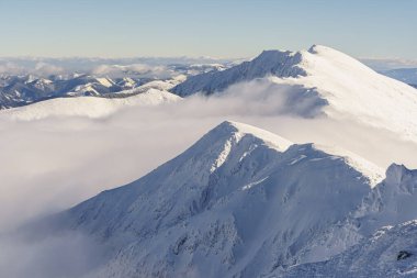 Bulut kaplı vadi ve karlı dağlar yukarıdan, güneşli, açık hava, kış, telefoto