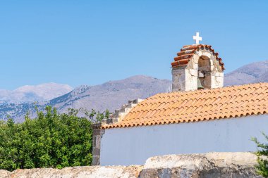 Haçlı kilise çatısı, arka planda yüksek verimsiz yerler, açık mavi gökyüzü, güneşli, Yunanistan, Girit adası, telefon lensleri