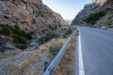 Kayalık dağ yamacında yol, vadi, açık mavi gökyüzü, Yunanistan, Girit adası, geniş açılı mercek