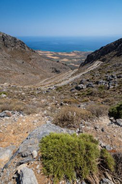 Çorak kayalık yamaçlarda serpentin yol açık mavi gökyüzü, Yunanistan, Girit adası, geniş açılı mercek