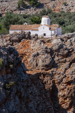 Kayalık bir uçurumun kenarındaki geleneksel kilise, güneş, Yunanistan, Girit adası, telefoto lensleri