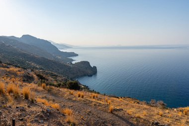 Kayalık dağları ve koyları olan sahil, açık mavi gökyüzü, güneşli, manzara, Yunanistan, Girit adası, telefoto lensleri