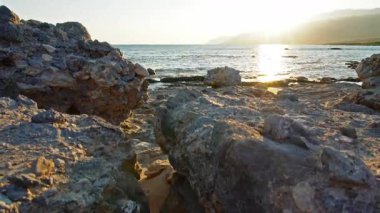 Yunan adası Girit 'te nefes kesen bir gün batımı, kameranın ilk kez dokulu ön plan kayaları ve hafif dalgalı denizi çektiği yer..