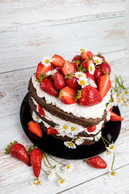 Çilekli çikolatalı kek, papatya çiçeği süslemeli.