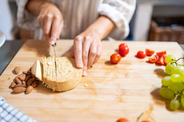 女性の手は朝食のためのアーモンドビーガンチーズのスライスを切断 — ストック写真