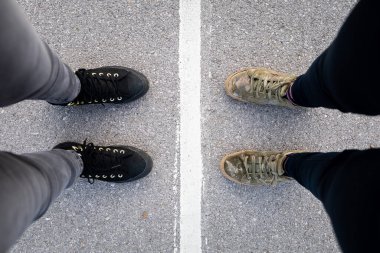 Beyaz bir çizgiyle ayrılan iki kişi. Ayrılma, sınır