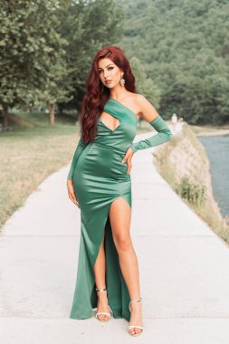 Genç kızıl saçlı, zarif yeşil ipeksi elbiseli, balo için hazır.