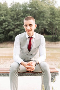 Gri takım elbiseli genç bir çocuk balo gecesine hazır. Boşluğu kopyala