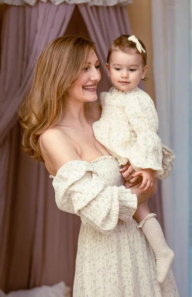 Stock image Young blonde, elegant mother holding her baby girl