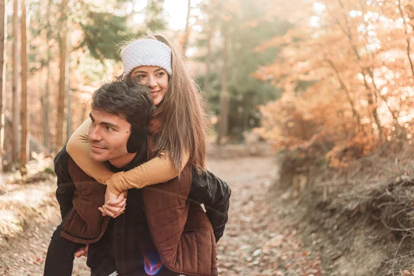 森の中の若いロマンチックなカップル ピギーバックに乗る 一緒に幸せ — ストック写真