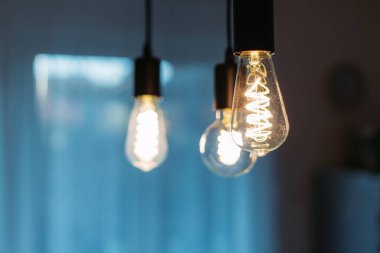 Odadaki tavandan sarkan ampullerin yakın çekimi.