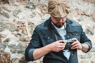 Sarmaşık şapkalı yakışıklı bir adamın portresi, kamerasına bakıyor.