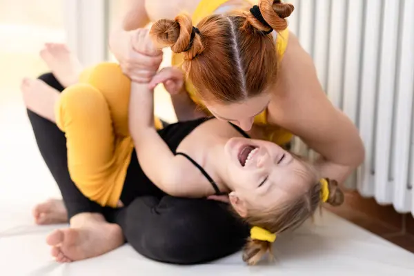 Young fit mom having loving time with her daughter