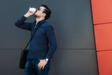 Delikanlı dışarıda kahve içiyor.