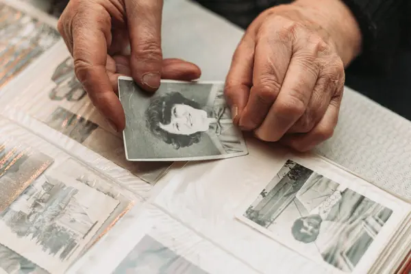 CIRCA 1970: Genç halinin klasik, siyah beyaz fotoğrafını tutan yaşlı kadın. Zaman kavramı geçiyor