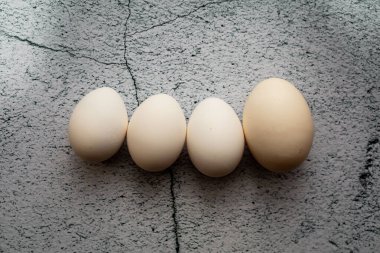 Boş bir arkaplanda dört beyaz yumurta. Paskalya konsepti