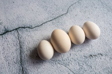 Boş bir arkaplanda dört beyaz yumurta. Paskalya konsepti