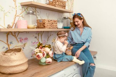 Anne kızına oyuncak tavşanı gösteriyor. Doğu