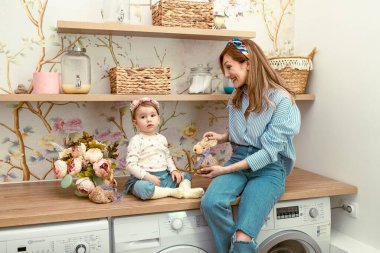 Anne kızına oyuncak tavşanı gösteriyor. Doğu