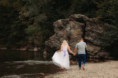Birbirine aşık bir çift nehir kenarında yürüyor. Boşluğu kopyala