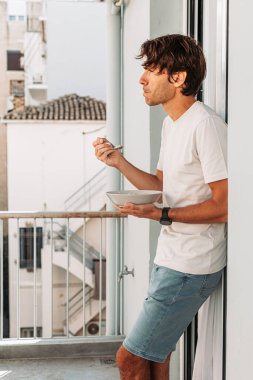 Atina 'daki terasta mısır gevreği yiyen genç adam