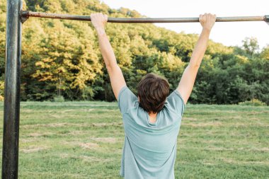 Parkta barfiks çeken genç adam.