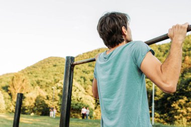 Parkta barfiks çeken genç adam.