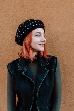 Gülümseyen Kızıl Saçlı Diş telleriyle Kış Giysilerinde Poz Veren Genç Kız